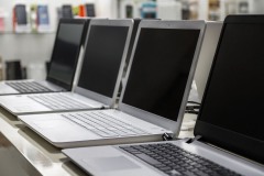 A row of laptops in computer shop. Closeup, selective focus